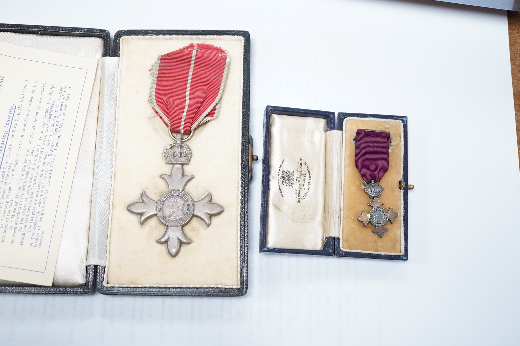 A cased George V military MBE containing leaflet with instructions as to wearing Insignia, together with the separately cased miniature. Condition - fair to good